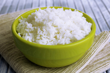 Cooked rice in bowl on wooden background