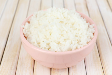 Cooked rice in bowl on wooden background