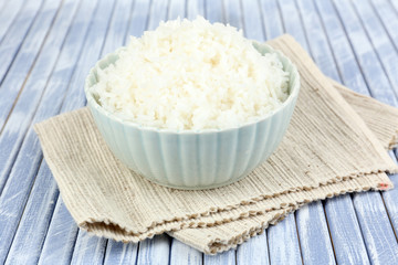 Cooked rice in bowl on wooden background