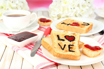 Delicious toast with jam and cup of tea on table close-up