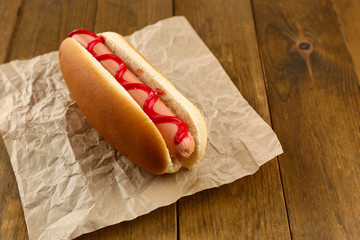 Tasty hot dog on wooden table