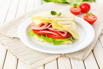 Tasty sandwich with ham on wooden table