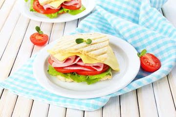 Tasty sandwich with ham on wooden table