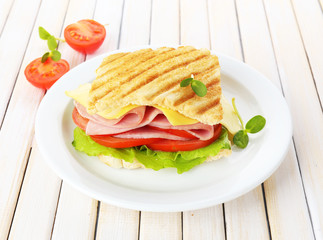 Tasty sandwich with ham on wooden table