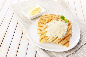 Grilled bread with butter on wooden table
