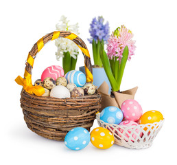 Easter eggs in a basket and spring flowers. White background