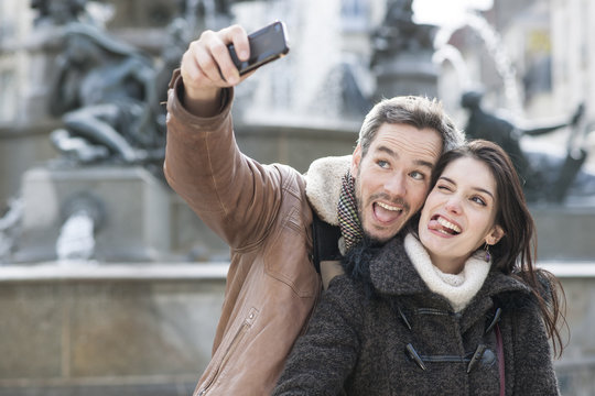 young couple taking a selfie of their grimaces