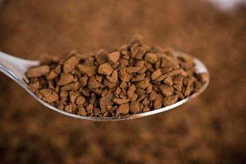 Spoon of coffee at coffee background