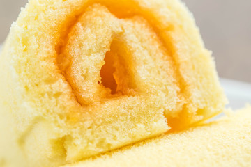 close up  slice roll cake on white plate,orange cake.
