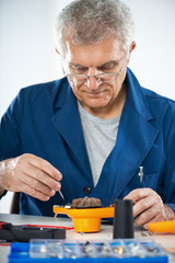 Senior adult Electrician repairing old hair dryer.