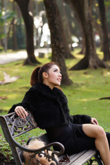 Beautiful Asian lady in black dress, posing in the park, greener