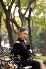 Beautiful Asian lady in black dress, posing in the park, greener