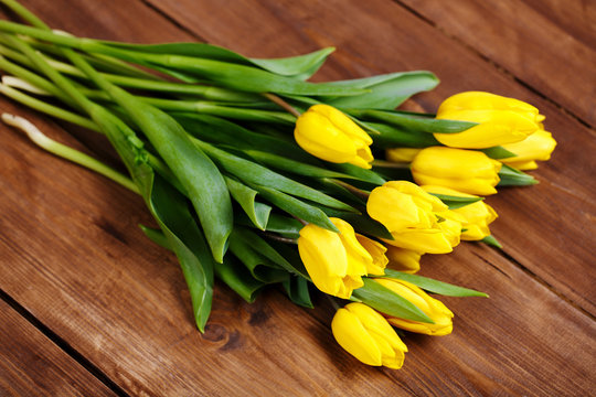 banch of Yellow tulips lying on wooden boards