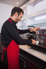 Smiling attractive barista making cup of coffee
