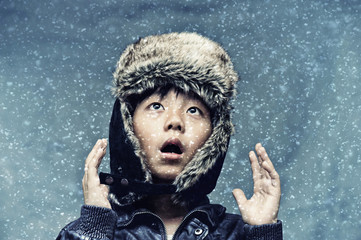 Cute boy surprised by snowfall