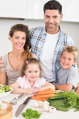Smiling family preparing vegetables together