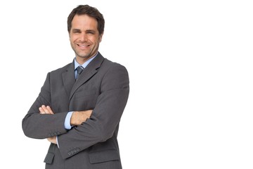 Handsome businessman smiling at camera with arms crossed