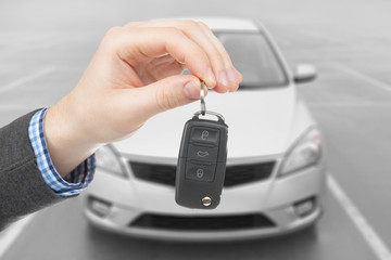 Male holding car keys with remote control system