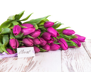 Purple tulips on wood background 