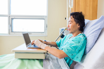 Patient Using Laptop On Bed In Hospital