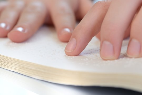 Finger ertasten Braille in einem Buch