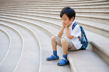 Sad boy sitting on stairs - 61399216