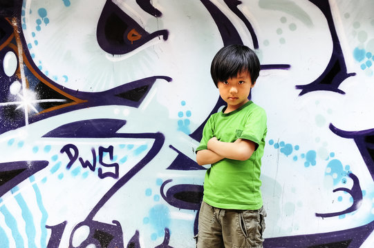 Cool Chinese boy in front of graffiti wall