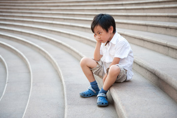 Sad boy sitting on stairs