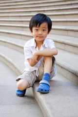 Cute schoolboy sitting on the stairs