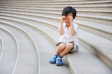 Fototapeta na wymiar Asian boy crying on stairs