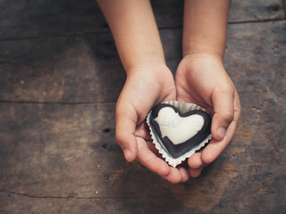 Love note on black and white chocolate in kid's hand