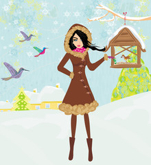 Fototapeta na wymiar girl feeds the birds in winter