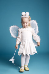 Fototapeta premium Cute little girl with butterfly costume on blue background