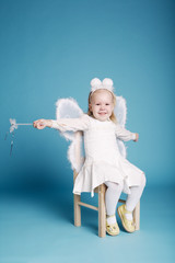 Cute little girl with butterfly costume on blue background