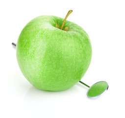 Green apple and dental tools isolated on white