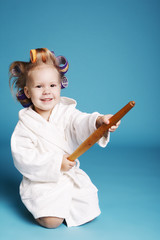 young housewife with rolling pin on blue background