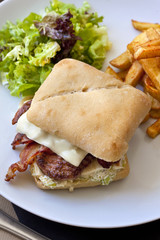 Hamburger avec bacon et steak, frites et salade