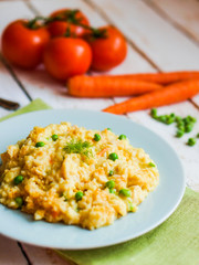 Rice with vegetables and chicken on white wooden background