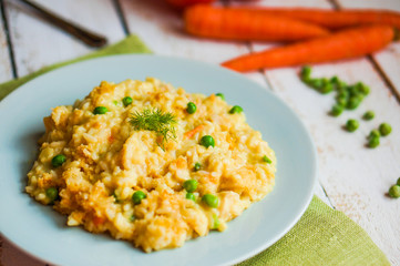 Rice with vegetables and chicken on white wooden background