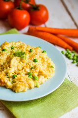 Rice with vegetables and chicken on white wooden background