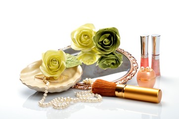 Items for decorative cosmetics, makeup, mirror and flowers