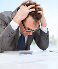 businessman with papres, laptop and calculator