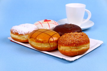Five delicious, assorted donuts with coffee cup