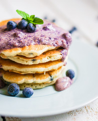 Blueberry pancakes on white wooden background