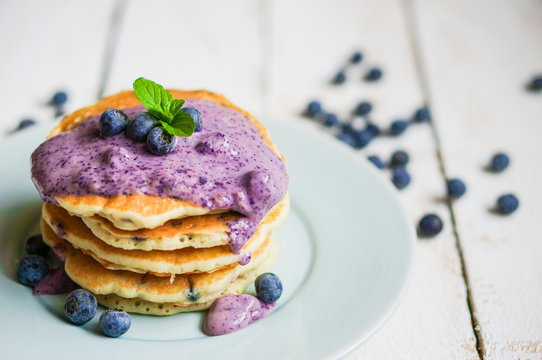 Blueberry pancakes on white wooden background