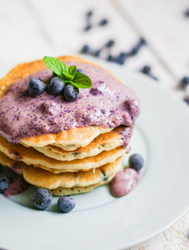 Blueberry pancakes on white wooden background