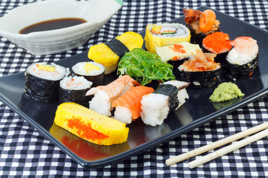 Japanese seafood sushi , and chopstick on a black plate