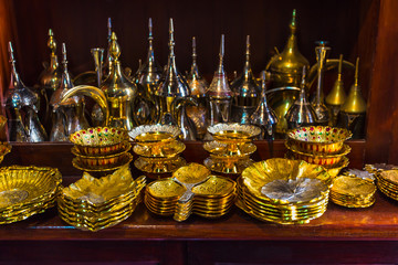 row of shiny traditional coffee pots and lamp