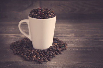 White cup filled with coffee bens with a vintage look