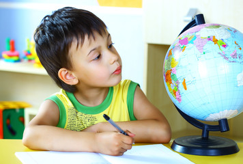 boy studying a globe